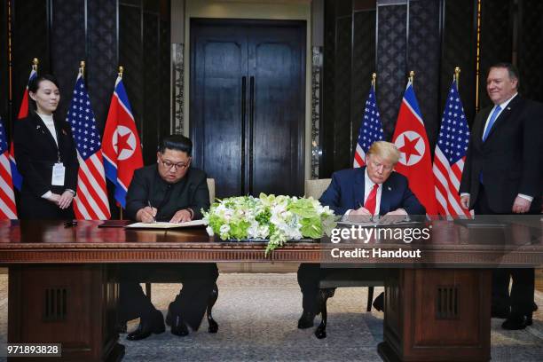 In this handout photograph provided by The Strait Times, North Korean leader Kim Jong-un with U.S. President Donald Trump during their historic...