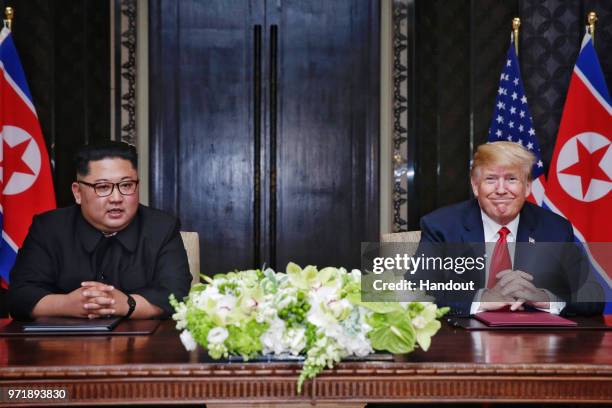 In this handout photograph provided by The Strait Times,, North Korean leader Kim Jong-un with U.S. President Donald Trump during their historic...