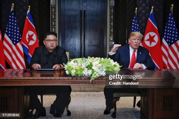 In this handout photograph provided by The Strait Times, North Korean leader Kim Jong-un with U.S. President Donald Trump during their historic...