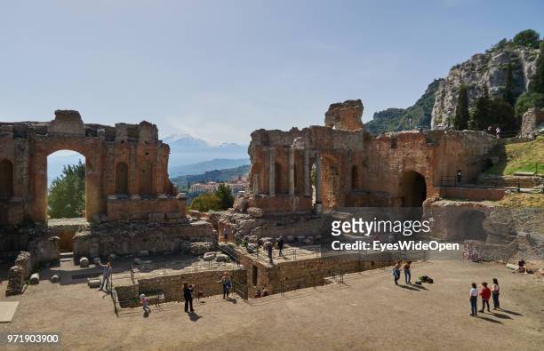 People in the Teatro Greco, the ancient greek theatre that is facing Mount Etna on April 8, 2018 in Taormina, Sicily, Italy.