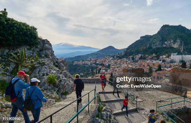 People in the Teatro Greco, the ancient greek theatre that is facing Mount Etna on April 8, 2018 in Taormina, Sicily, Italy.