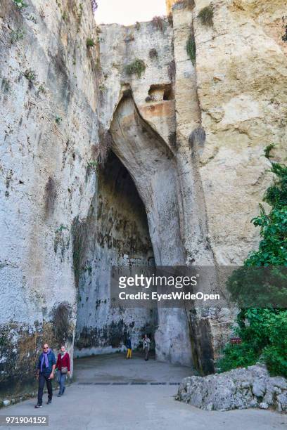 People at the famous rock formation with echo - Orecchio di Dionisio - in the Archeological Park on April 9, 2018 in Syracuse, Sicily, Italy.