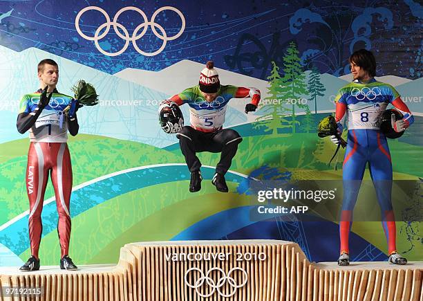 Canada's Jon Montgomery celebrates winning gold with Latvia's Martins Dukurs who won silver and Alexander Tretyakov of Russia who won bronze in the...