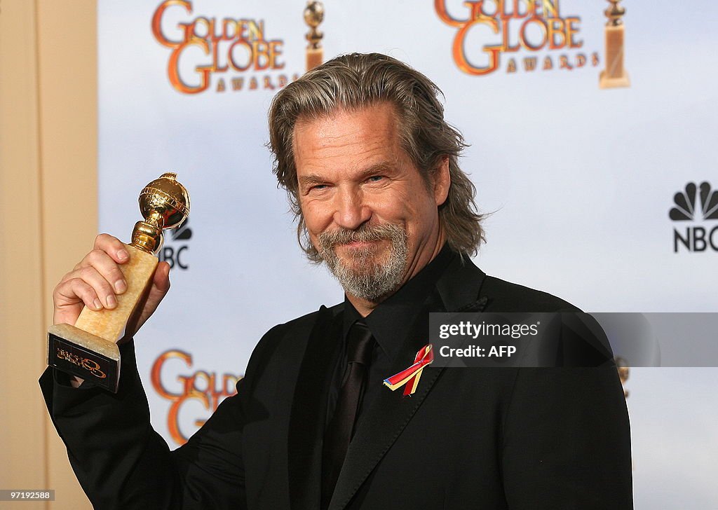 Actor Jeff Bridges poses with his award for best performance by an ...