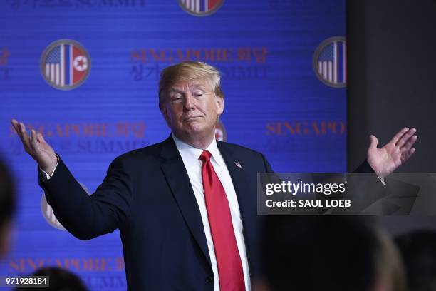 President Donald Trump gestures after a press conference following the historic US-North Korea summit in Singapore on June 12, 2018. - Trump and...