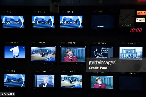 German Chancellor Angela Merkel is dispalyed on different TV screens at public German television channel ARD during an interview broadcasting...