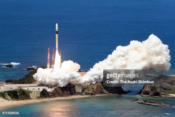 In this aerial image, the H-IIA F39 rocket, carrying an intelligence-gathering government satellite, lifts off from the launch pad at the Japan...