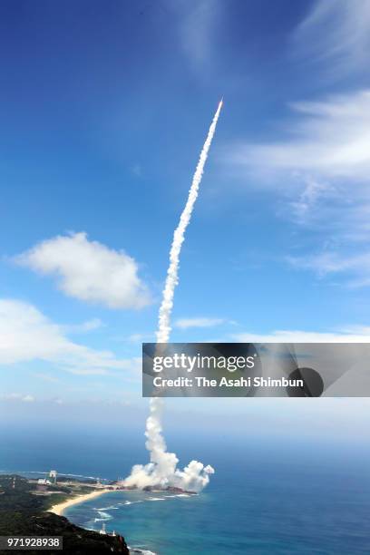 In this aerial image, the H-IIA F39 rocket, carrying an intelligence-gathering government satellite, lifts off from the launch pad at the Japan...