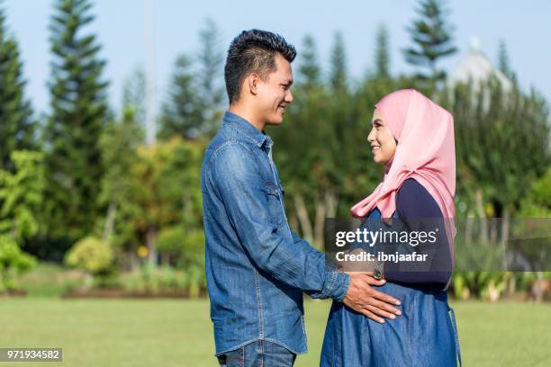 young couple pregnant women with husband - pregnant muslim stock pictures, royalty-free photos & images