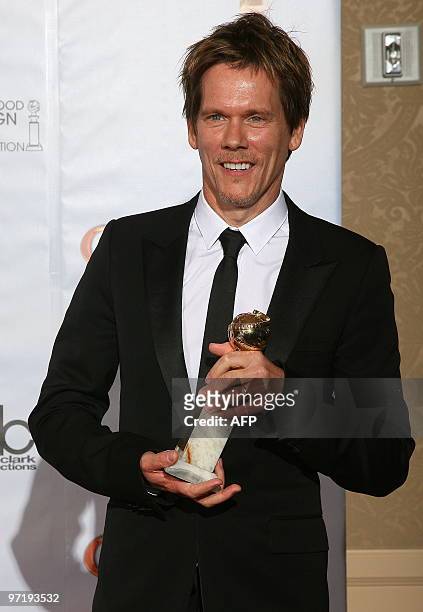 Kevin Bacon holds his award for best actor in a mini-series or TV movie for his role in 'Taking Chance' in the photo room at the 67th Annual Golden...