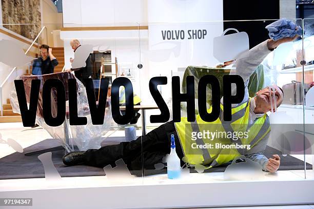 An employee cleans a Volvo stand prior to the official opening of the Geneva International Motor Show in Geneva, Switzerland, on Monday, March 1,...