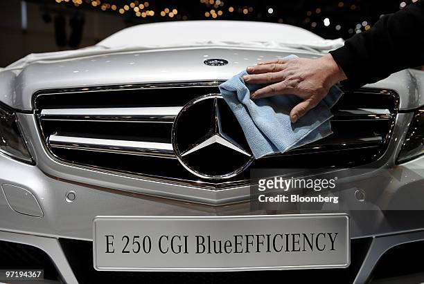 An employee cleans a Daimler Mercedes E250 CGI BlueEFFICIENCY automobile prior to the official opening of the Geneva International Motor Show in...