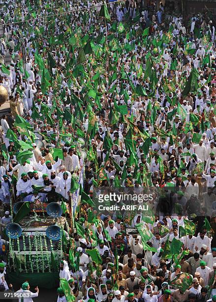 Pakistani Muslims wave green flags as they march in an Eid Milad-un-Nabi festival procession in Lahore on February 27, 2010. Thousands of Muslims...