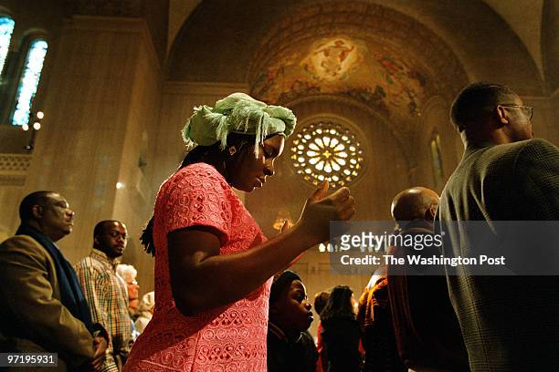 P/basilica jahi chikwendiu/TWP Vivien Oicorafor, a Nigerian living in Riverdale, MD, prays during mass at the Basilica of the National Shrine of the...