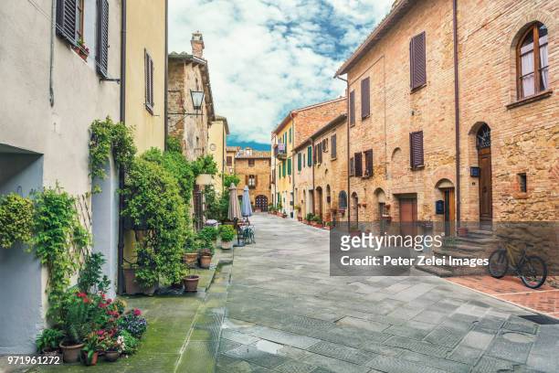 old italian town in tuscany - bicycle flowers stockfoto's en -beelden