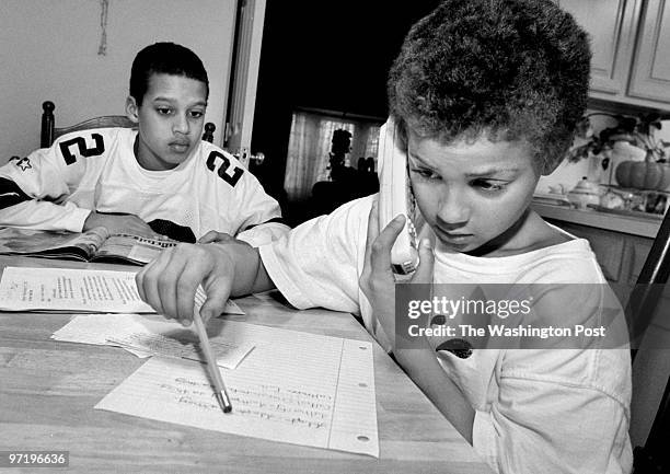 Year-old Anthony King waits his turn to talk to mom as 9-year-old Ja-Van Stewart talks to their mother Corry Stewart who called from her cellphone....