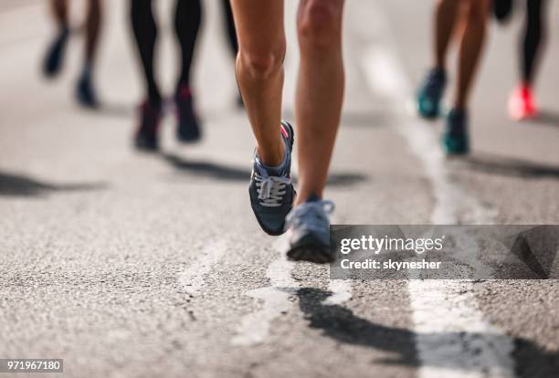 onherkenbaar marathonloper in beweging op de weg. - halve marathon stockfoto's en -beelden