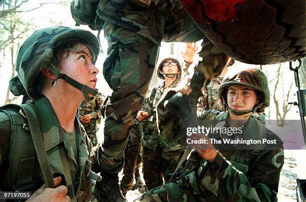 Marines Marine recruits Alexandra Murphy, left, and Candice Fleming, right, from Fredericksburg, VA, help another recruit pass an obstacle during the...