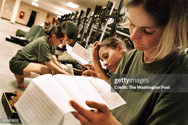 Marines Jahi Chikwendiu/TWP Valerie Hawver of Green Bay, WI, and Jessica Jweinat of Millbrae, CA, read letters from home at Marine boot camp on...