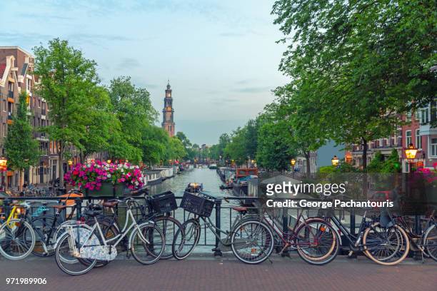 bicycles on a bridge in prinsengracht canal, amsterdam - amsterdam bike stockfoto's en -beelden