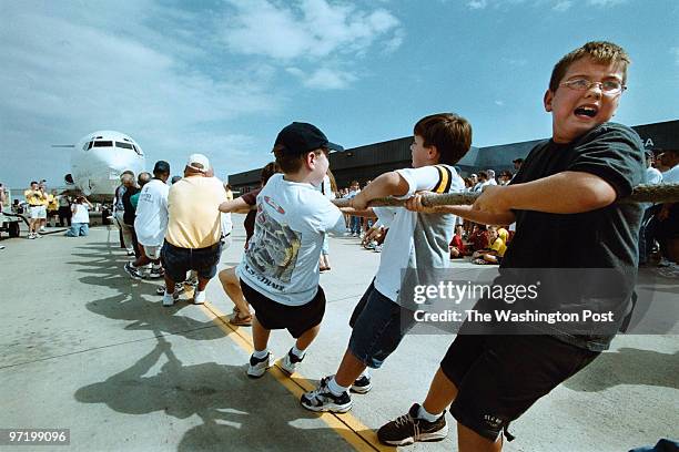 Woodwardt 131091 10th Annual Dulles Day Family Festival, featuring plane pulls-tug of war between humans and machines. From right, boy looking back,...