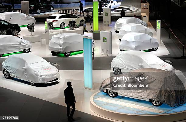 An employee passes through the Toyota stand prior to the official opening of the Geneva International Motor Show in Geneva, Switzerland, on Monday,...