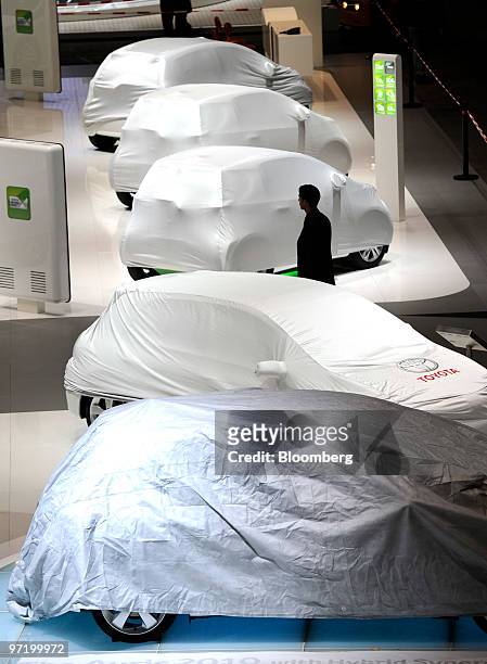 An employee passes through the Toyota stand prior to the official opening of the Geneva International Motor Show in Geneva, Switzerland, on Monday,...