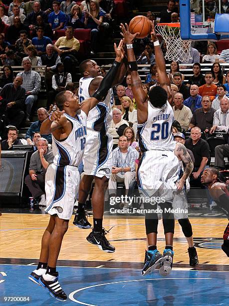 Dwight Howard, Brandon Bass and Mickael Pietrus of the Orlando Magic reach for a rebound against the Miami Heat during the game on February 28, 2010...