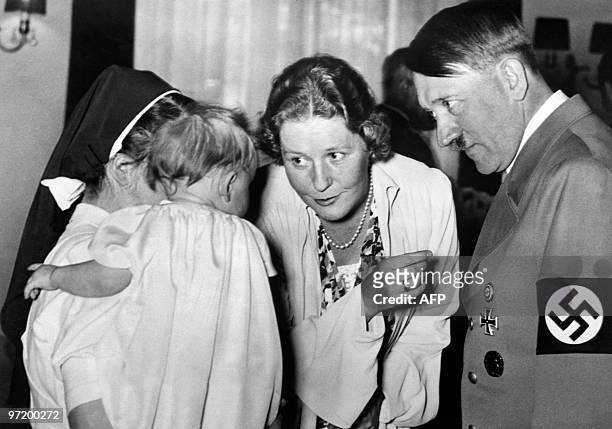 Picture dated 1939 shows German nazi Chancellor and dictator Adolf Hitler with Emmy Goering talking to a baby hold by a nun. AFP PHOTO / FRANCE...