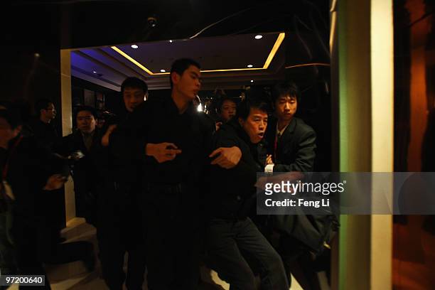 Chinese protester is pushed away by security before a news conference by Toyota President Akio Toyoda on March 1, 2010 in Beijing, China. Toyoda...