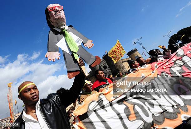 An immigrant holds a puppet depicting Italian Interior minister Roberto Maroni during the first "Day without immigrants" demonstration on March 1,...