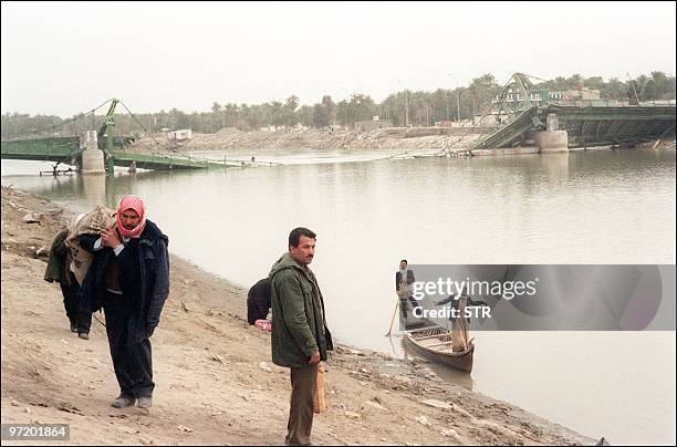 Inhabitants of Samawa, 250kms south of Baghdad, shown in a file photo dated 17 February 1991 using small boats to cross the Euphrates river as three...