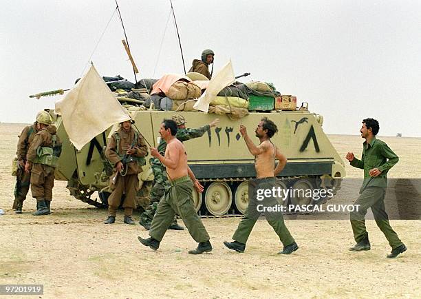 Two Iraqi soldiers wave the white flag as they surrender to Egyptian forces 25 February 1991 somewhere in Kuwaiti desert on the second day of the...