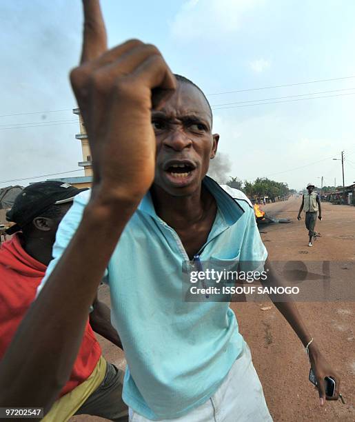An opposition member gestures on a road the western town of Gagnoa on February 20, 2010 as they protest against Ivorian President Laurent Gbagbo...