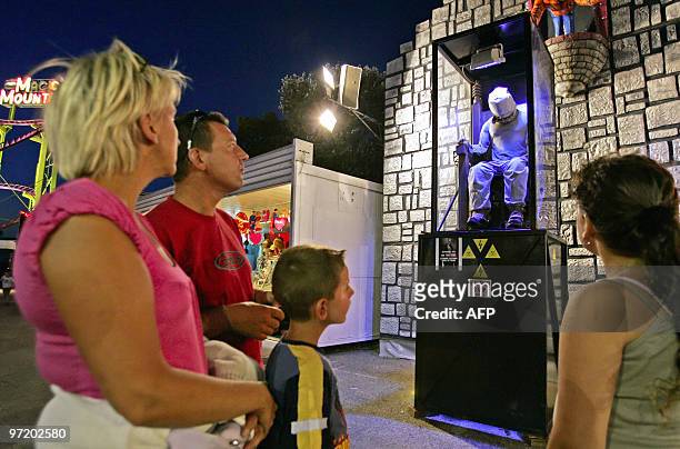 Picture taken on August 20, 2008 shows spectators watching a human dummy simulating an execution by electric chair at a game park in Frejus,...