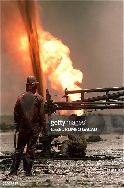 Red Adair fire fighting crew work 30 March 1991 on a blown-out well damaged by retreating Iraqi soldiers in Al-Ahmadi oil field in southern Kuwait....