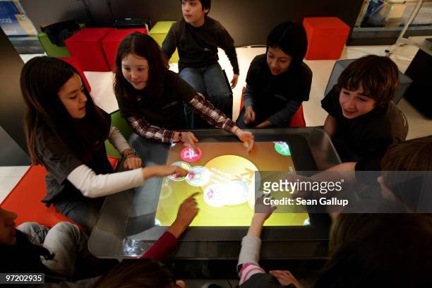 Children try out a touch-screen digital learning table in the Digitial Classroom at the Microsoft stand at the CeBIT Technology Fair on March 1, 2010...