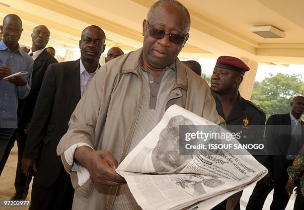 Ivory Coast president Laurent Gbagbo looks at a newspaper after a meeting with Ivorian prime minister Guillaume Soro in the presidential palace in...