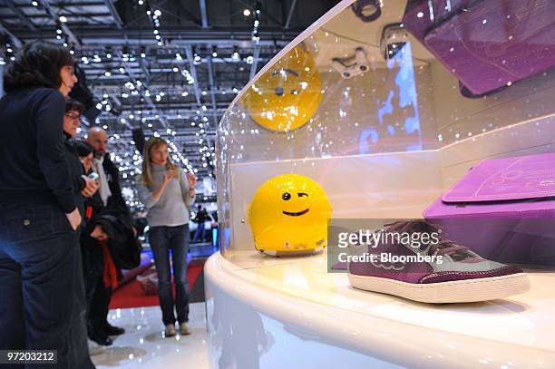 Visitors look at a display case containing Fiat SpA 500 shoes prior to the official opening of the Geneva International Motor Show in Geneva,...