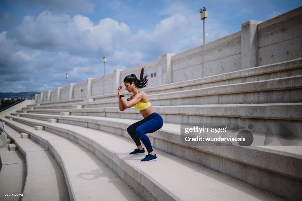 Mujer escuchando música y haciendo ejercicio en escaleras urbanas