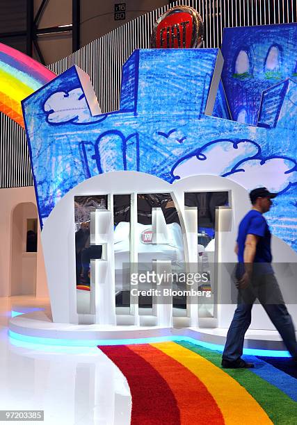 An employee passes a Fiat SpA logo prior to the official opening of the Geneva International Motor Show in Geneva, Switzerland, on Monday, March 1,...