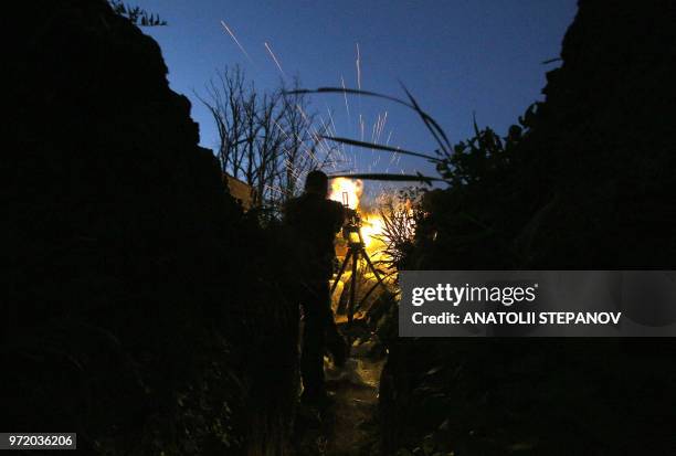 Ukrainian serviceman fires a machine gun in the direction of Russia-backed separatists during night combat near the southeastern city of Mariupol...