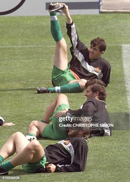 Bulgarian soccer player Ivaylo Yordanov stretches as teammates Trifon Ivanov and Emil Kostadinov relax, 11 June during a training session at the...