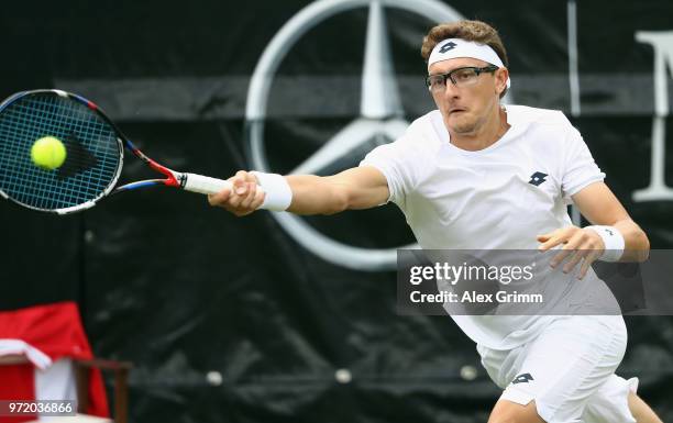 Denis Istomin of Uzbekistan plays a forehand to Philipp Kohlschreiber of Germany during day 2 of the Mercedes Cup at Tennisclub Weissenhof on June...