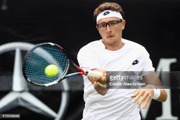 Denis Istomin of Uzbekistan plays a forehand to Philipp Kohlschreiber of Germany during day 2 of the Mercedes Cup at Tennisclub Weissenhof on June...