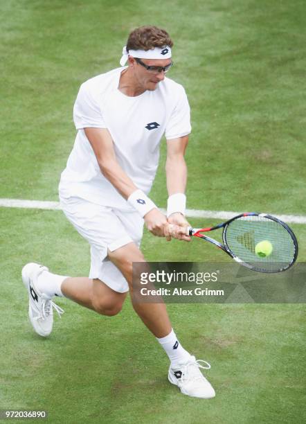 Denis Istomin of Uzbekistan plays a backhand to Philipp Kohlschreiber of Germany during day 2 of the Mercedes Cup at Tennisclub Weissenhof on June...