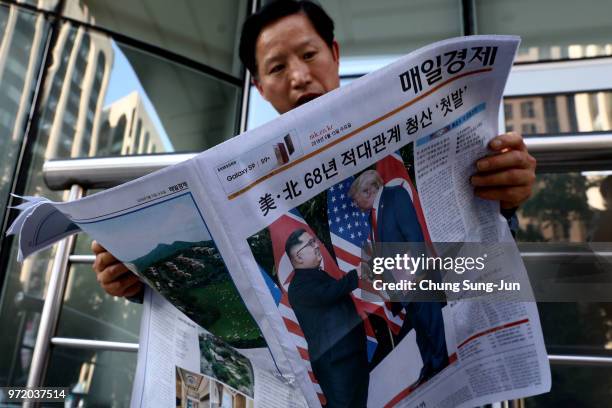 South Korean man reads a newspaper reporting the U.S. President Trump meeting with North Korean leader Kim Jong-un on June 12, 2018 in Seoul, South...
