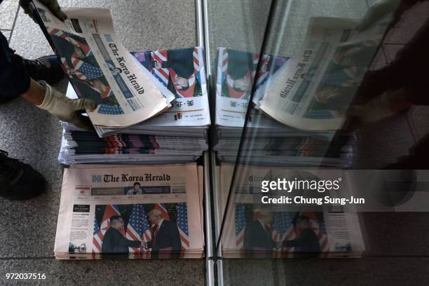South Korean newspaper deliveryman collects newspapers reporting the U.S. President Trump meeting with North Korean leader Kim Jong-un on June 12,...