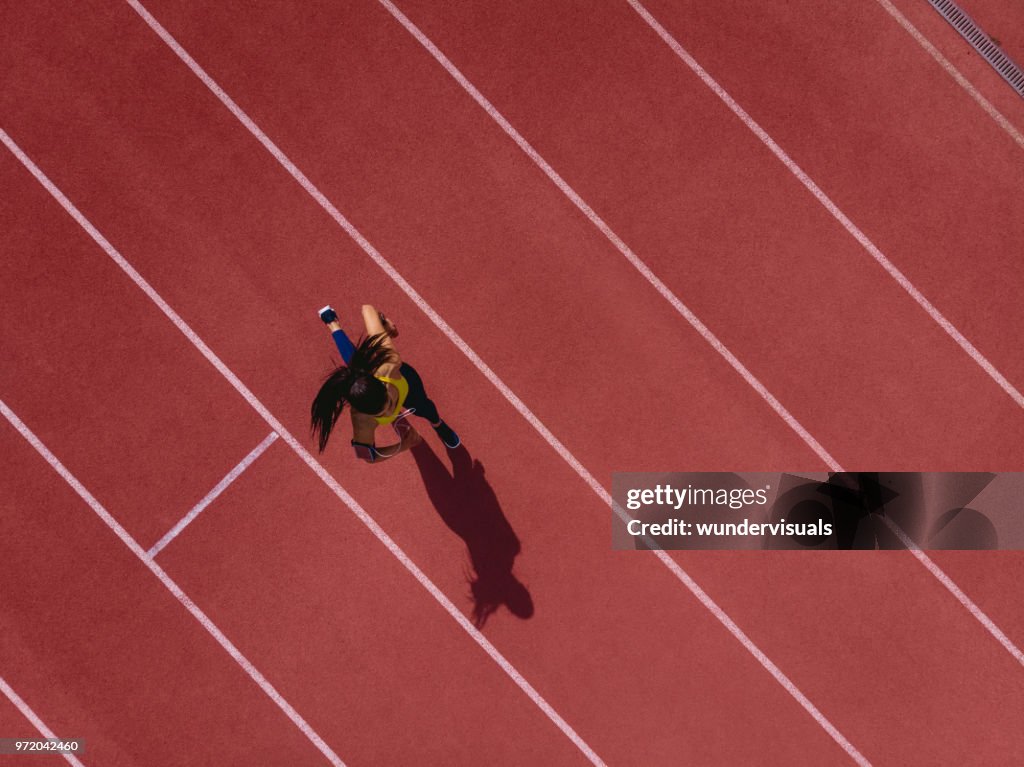 Corredor mujer escuchando música y ejecución en deportes de pista