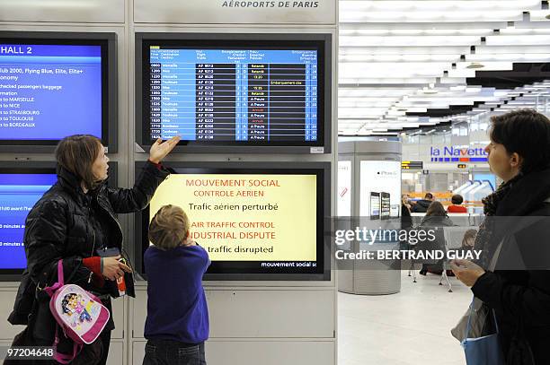 Passengers wait in front of a screen announcing an air traffic control dispute on February 25, 2010 at Paris' Orly airport. Several flights were...